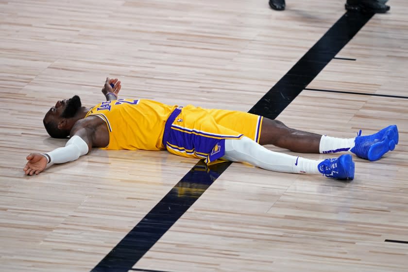 Los Angeles Lakers forward LeBron James (23) lies on the court after committing a foul during the second half.