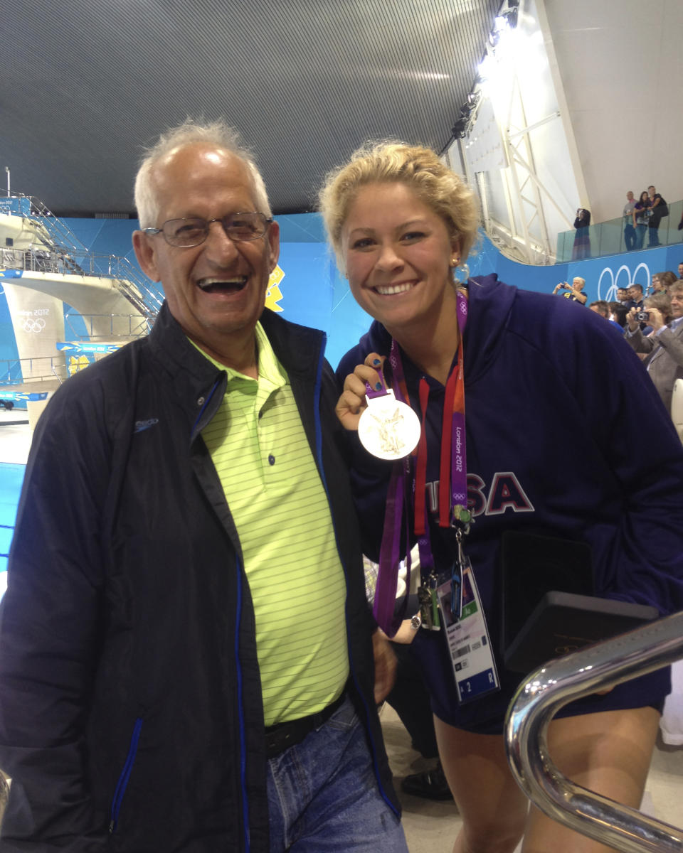 In this July 2012 photo provided by Joan Beisel, Olympic medalist swimmer Elizabeth Beisel, right, stands for a photo with her father Ted Beisel, left, at the 2012 Olympics, in London. Beisel competed in three Olympics, but she's never taken on a challenge quite like this. She will attempt to become the first woman to swim from the Rhode Island mainland to Block Island. The 10.4-mile swim is to honor her father, who died July 1 after being diagnosed with pancreatic cancer. Beisel has raised more than $121,000 for the fight against cancer and knows that she brought some meaning to her father's life in his final months. (Joan Beisel via AP)