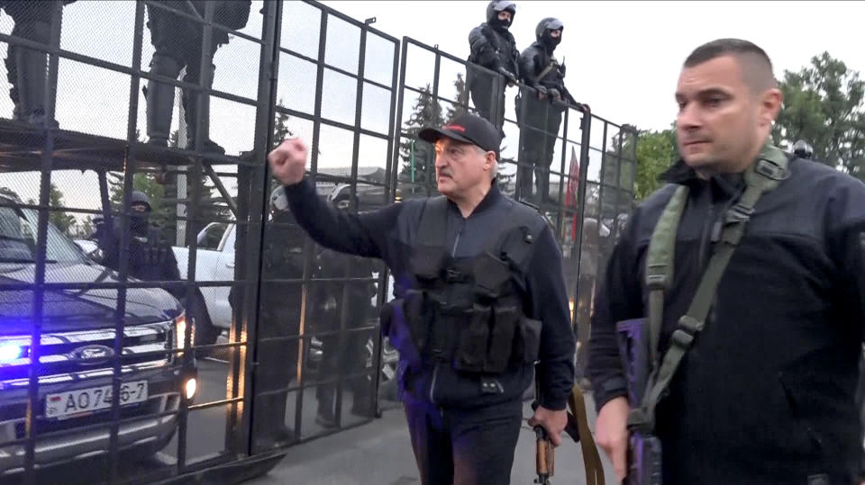 This image made from video provided by the State TV and Radio Company of Belarus, shows Belarus President Alexander Lukashenko armed with a Kalashnikov-type rifle greeting riot police officers near the Palace of Independence in Minsk, Belarus, Sunday, Aug. 23, 2020. Lukashenko has made a dramatic show of defiance against the massive protests demanding his resignation, toting a rifle and wearing a bulletproof vest as he strode off a helicopter that landed at his residence while demonstrators massed nearby. (State TV and Radio Company of Belarus via AP)