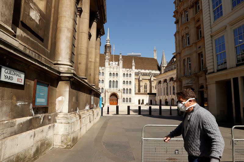 FILE PHOTO: A man wearing a mask outside Guildhall in the city of London as the spread of the coronavirus disease (COVID-19) continues,