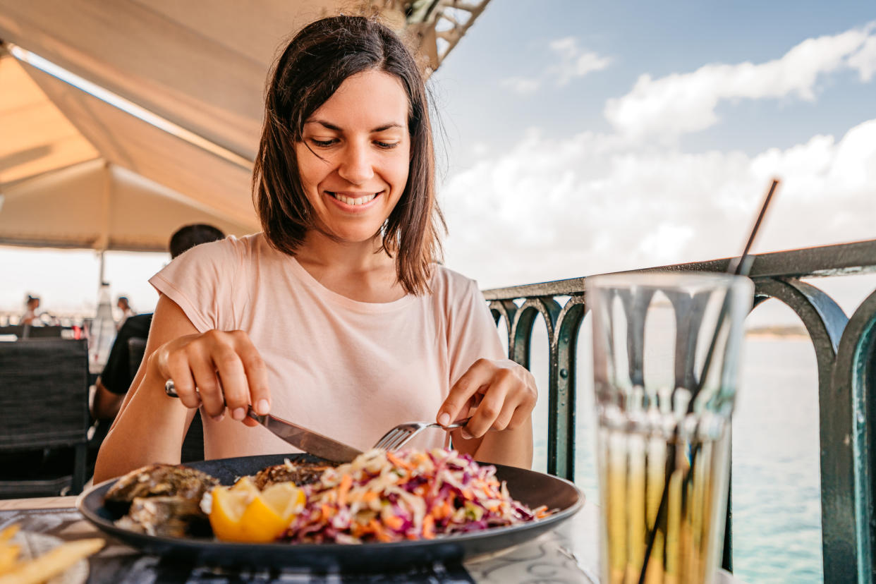 Woman having dinner on vacation.  (Getty Images)