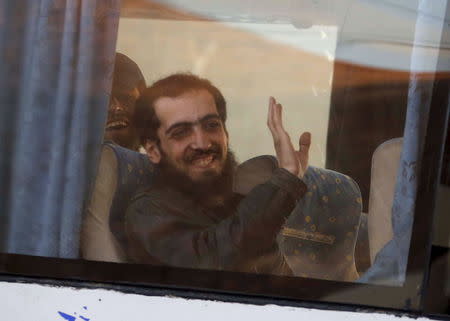 A fighter from the besieged rebel-held Syrian town of Zabadani gestures from inside a bus upon his arrival at the Masnaa border crossing between Lebanon and Syria, December 28, 2015. REUTERS/Mohamed Azakir