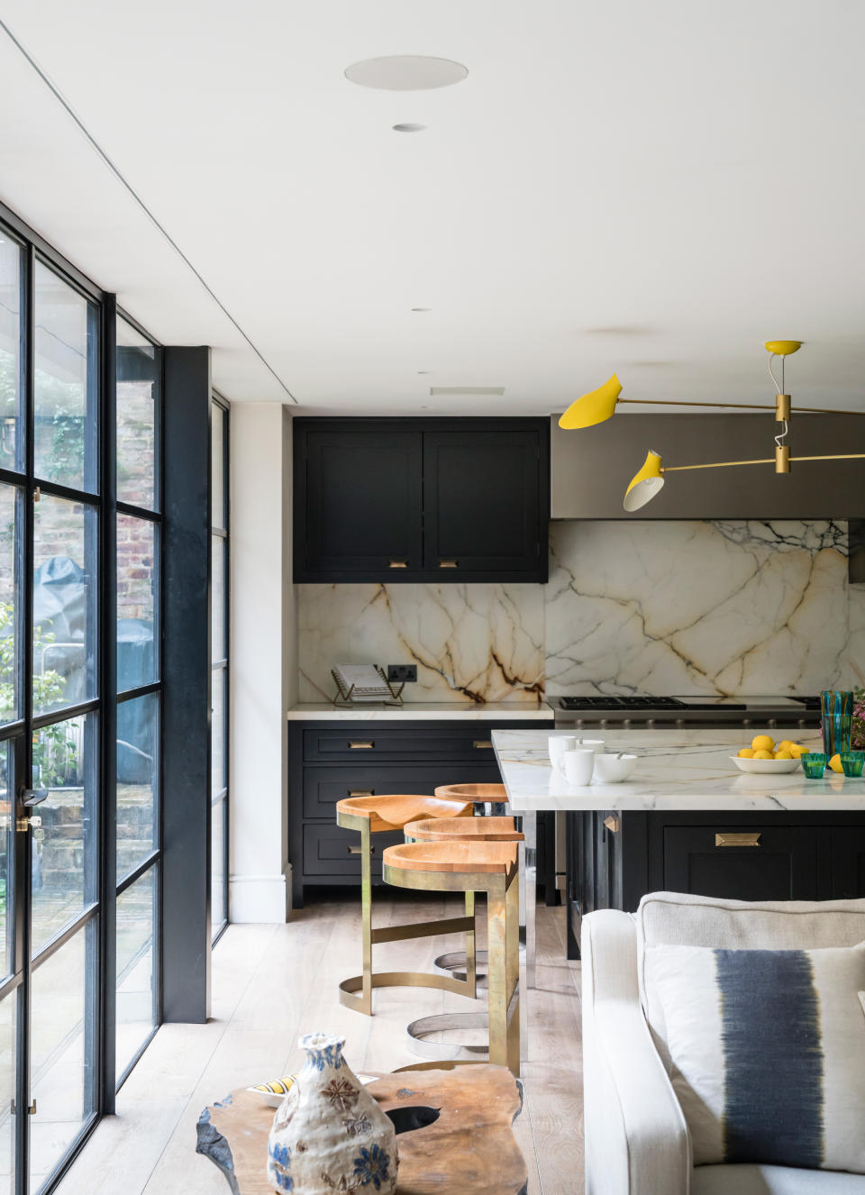 Dark blue open plan kitchen with marble slab backsplash