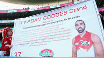 A fan holds a sign with 'The Adam Goodes Stand' on it.