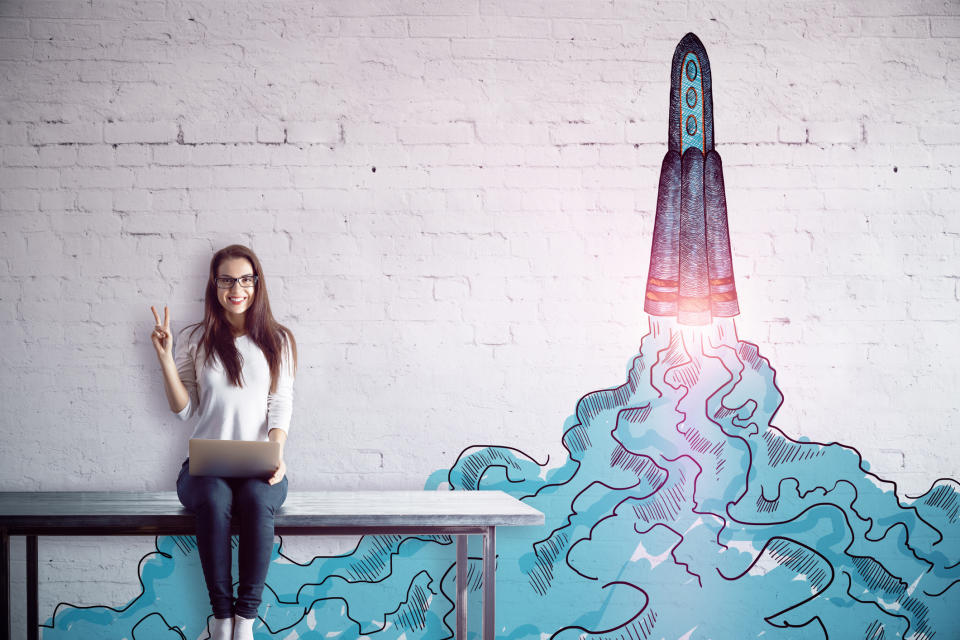 A woman sitting on a bench next to a drawing of a rocket leaving the ground