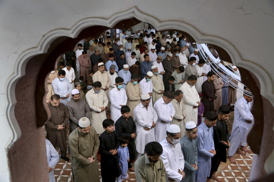 Muslims perform an Eid al-Fitr prayer at a mosque, in Peshawar, Pakistan, Thursday, May 13, 2021. Millions of Muslims across the world are marking a muted and gloomy holiday of Eid al-Fitr, the end of the fasting month of Ramadan, a usually joyous three-day celebration that has been significantly toned down as coronavirus cases soar. (AP Photo/Muhammad Sajjad)