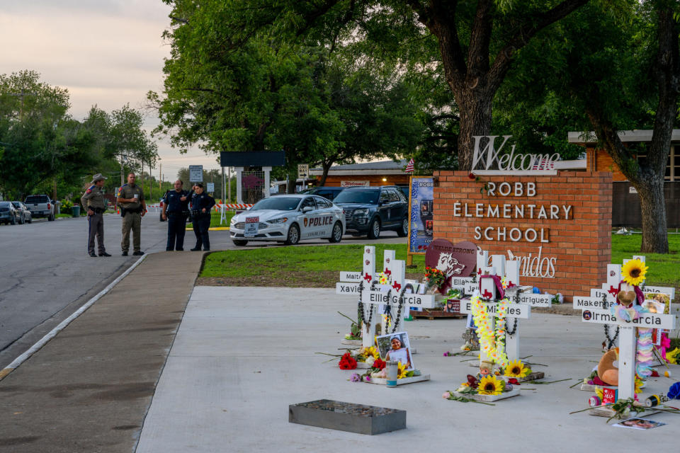 Law enforcement officers stand watch near a memorial dedicated to the 19 children and two adults murdered on May 24, 2022 during the mass shooting at Robb Elementary School. (Photo by Brandon Bell/Getty Images)