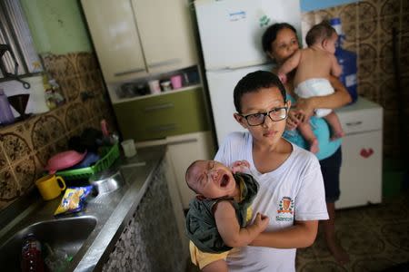 Paulo (C), 8, holds his five-month-old sister Laura as his grandmother Manyara (back), 46, holds her five-month-old grandson Lucas at their house in Santos, Sao Paulo state, Brazil April 20, 2016. REUTERS/Nacho Doce