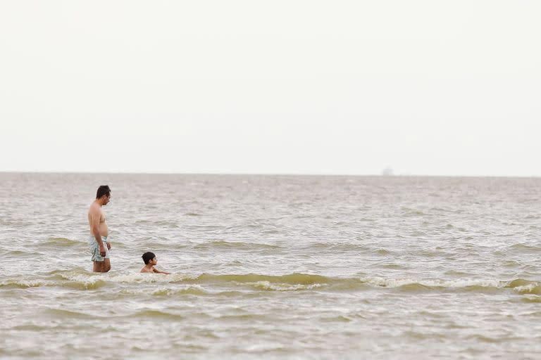 Pese a las advertencias de las autoridades, varias personas se bañan en las agua contaminadas con cianobacterias  