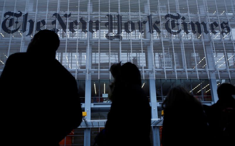 FILE PHOTO: People line up for taxi across the street from the New York Times head office in New York