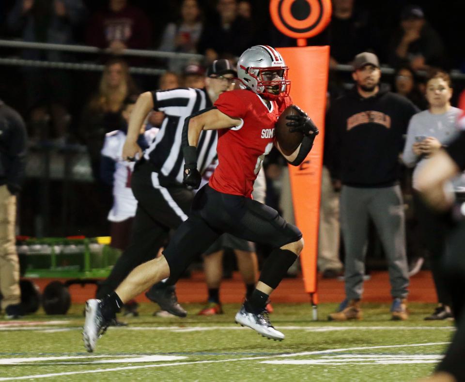 Somers' Luke Kennedy (6) runs back a first half interception for a touchdown against Harrison during playoff football action at Somers High School Nov. 4, 2022. 