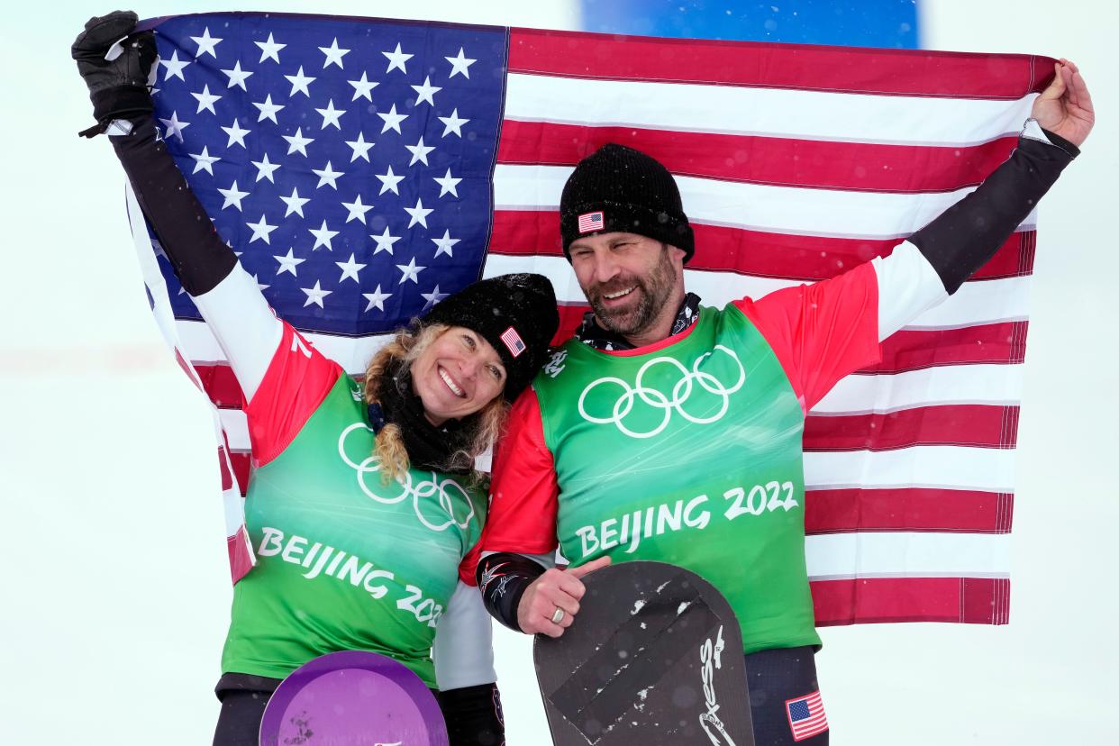 Lindsey Jacobellis, left, and Nick Baumgartner celebrate after winning gold in the mixed team snowboardcross at the 2022 Beijing Olympics.