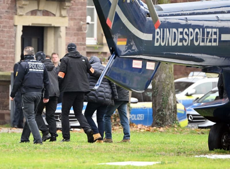 A suspect is taken out of a helicopter by police officers in the course of raids and arrests against the "Reich Citizens" movement. Authorities in Germany have charged a suspected member of the extremist Reich Citizens movement who is accused of supporting a group having planned to sail into Russian territorial waters to secure support for overthrowing the German state. Uli Deck/dpa