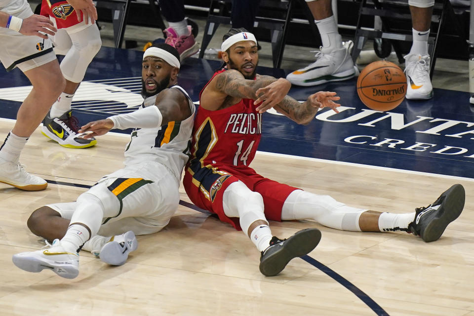 New Orleans Pelicans forward Brandon Ingram (14) passes the ball after fighting for a loose ball with Utah Jazz forward Royce O'Neale, left, during the second half of an NBA basketball game Thursday, Jan. 21, 2021, in Salt Lake City. (AP Photo/Rick Bowmer)