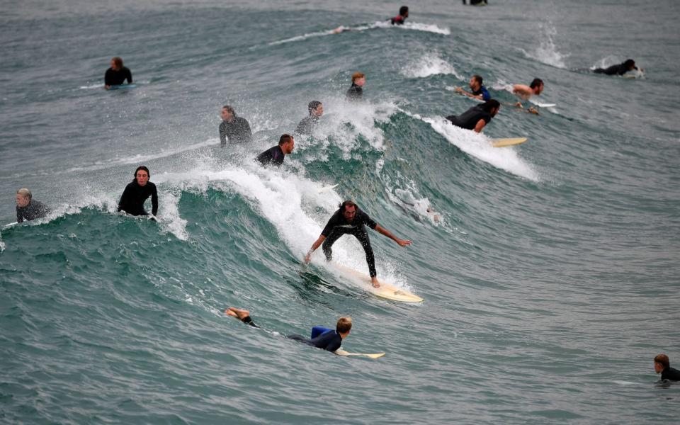 People surf at Maroubra Beach in Sydney on April 20, 2020 - AFP