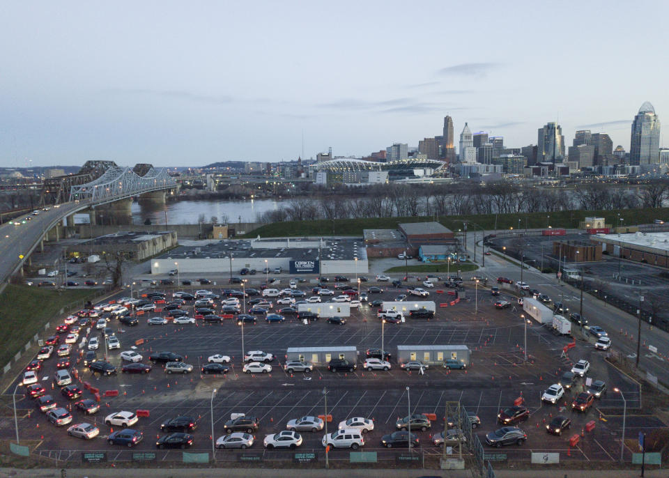 Cars line up around the block at a COVID testing site across the river from downtown Cincinnati in Covington, Ky., Monday, Jan. 3, 2022. (AP Photo/Jeff Dean)