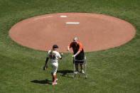 Bryan Stow is greeted by San Francisco Giants assistant coach Alyssa Nakken before throwing out the ceremonial first pitch before a baseball game against the Colorado Rockies, Friday, April 9, 2021, in San Francisco. Ten years ago Stow was attacked at Dodger Stadium. (AP Photo/Eric Risberg)