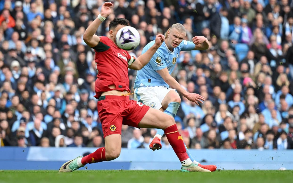 Max Kilman of Wolverhampton Wanderers attempts to defend as Erling Haaland of Manchester City scores his team's fourth goal