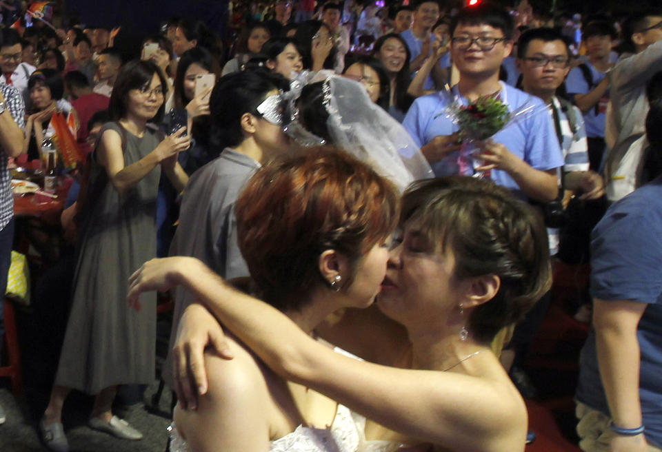 Taiwanese same-sex couples kiss at their wedding party in Taipei, Taiwan, Saturday, May 25, 2019. Taiwan became the first place in Asia to allow same-sex marriage last week. Hundreds of same-sex couples in Taiwan rushed to get married Friday, the first day a landmark decision that legalized same-sex marriage took effect. (AP Photo/Chiang Ying-ying)
