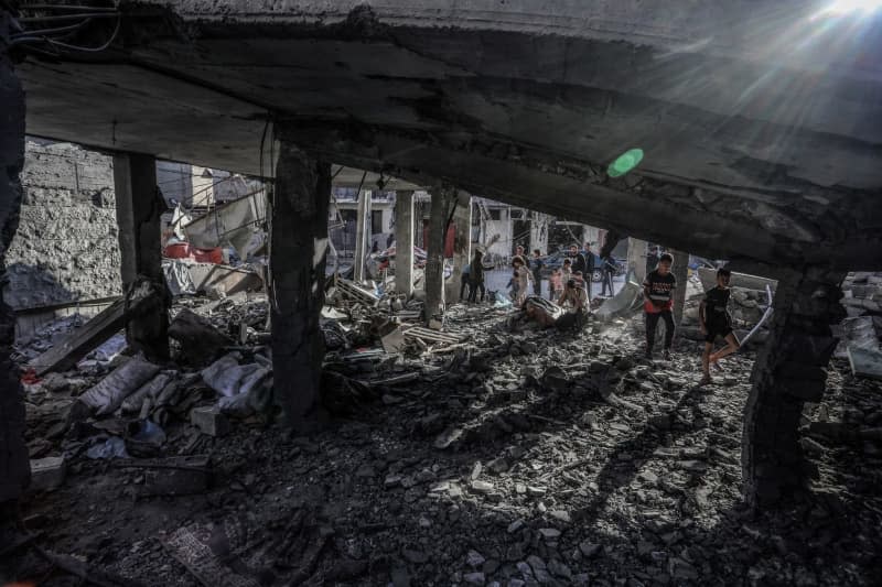 Palestinians inspect a house belonging to the Abu Al-Hinud family, after an Israeli air strike, which resulted in eight deaths and a number of injuries. Abed Rahim Khatib/dpa