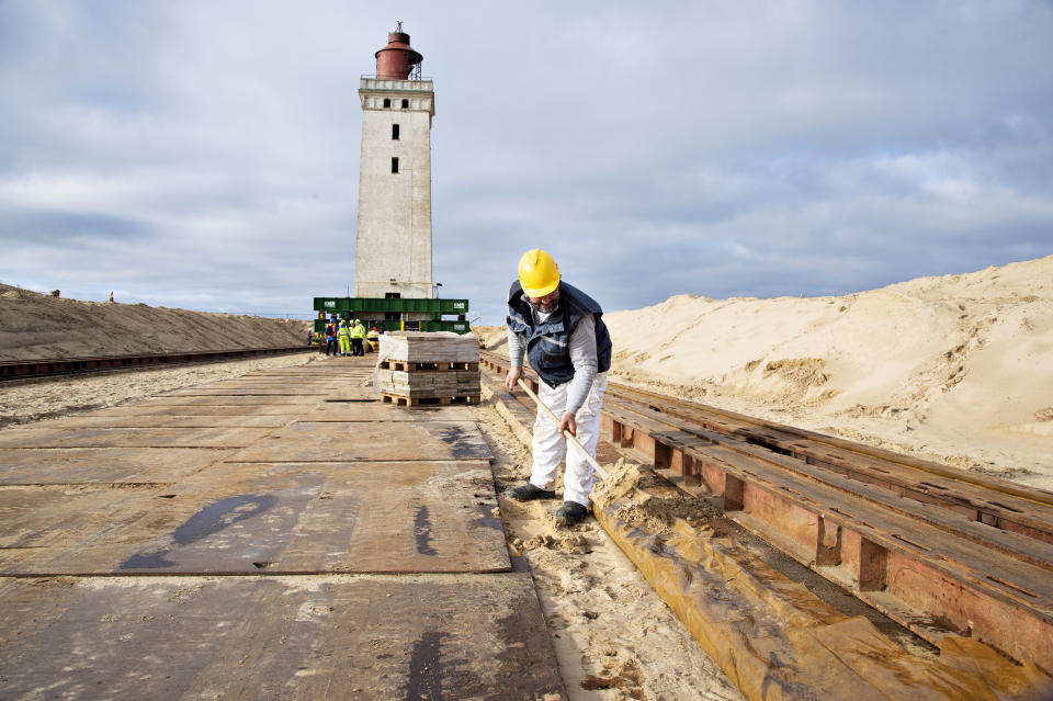 In this photo taken on Monday, Oct. 21, 2019, preparations are being made to move the Rubjerg Knude Lighthouse in Jutland, Denmark. A 120-year-old lighthouse has been put on wheels and rails to attempt to move it some 80 meters (263 feet) away from the North Sea, which has been eroding the coastline of northwestern Denmark. When the 23-meter (76 feet) tall Rubjerg Knude lighthouse was first lit, in 1990, it was roughly 200 meters (656 feet) from the coast; now it is only about 6 meters away. (Henning Bagger/Ritzau Scanpix via AP)