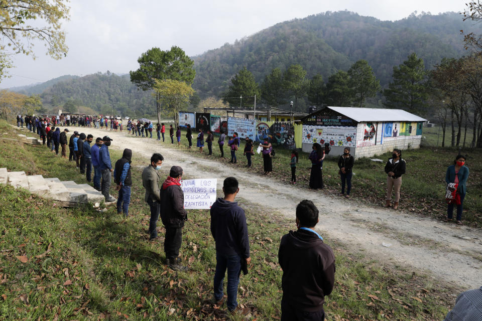 Members of the Zapatista Army of National Liberation, EZLN, line up on the side of the road to bid farewell to a delegation that will leave for Europe on May 3, in the community of Morelia, Chiapas state, Mexico, Monday, April 26, 2021. The rebels say they are planning to take canoes on a trip to ‘invade’ Spain in May and June, as Mexico marks the anniversary of the 1519-1521 Spanish Conquest of Mexico. (AP Photo/Eduardo Verdugo)