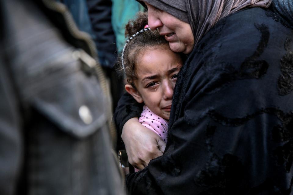 A Palestinian woman holds a child as they mourn their relatives killed in Israeli bombardment in front of the morgue of the Al-Shifa hospital in Gaza City on March 15, 2024, amid the ongoing conflict between Israel and the Palestinian Hamas movement.