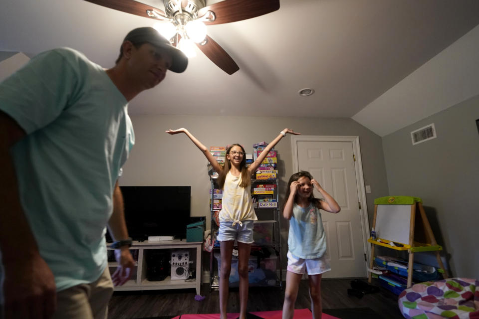 Cecilia Shaffette, center, reacts after doing a dance routine with her sister Lydia, in front of her father Rhett Shaffette at their home in Carriere, Miss., Wednesday, June 16, 2021. Twelve-year-old Cecilia is thriving, eight months after getting a portion of her father's liver. She received the transplant after nearly losing her life to internal bleeding. (AP Photo/Gerald Herbert)