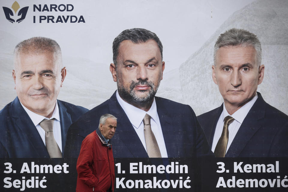 A man passes by an election poster of the candidates of the People and Justice Party (NiP) in Sarajevo, Bosnia, Tuesday, Sept. 27, 2022. Bosnia's upcoming general election could be about the fight against corruption and helping its ailing economy. But at the time when Russia has a strong incentive to reignite conflict in the small Balkan nation, the Oct 2. vote appears set to be an easy test for long-entrenched nationalists who have enriched cronies and ignored the needs of the people. (AP Photo/Armin Durgut)