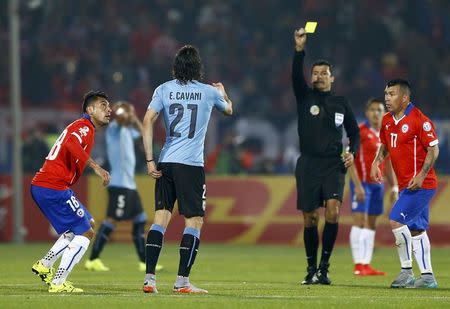 Referee Sandro Ricci shows a second yellow card to Uruguay's Edinson Cavani as Chile's Gonzalo Jara (18) looks on during their quarter-finals Copa America 2015 soccer match at the National Stadium in Santiago, Chile, June 24, 2015. REUTERS/Ivan Alvarado