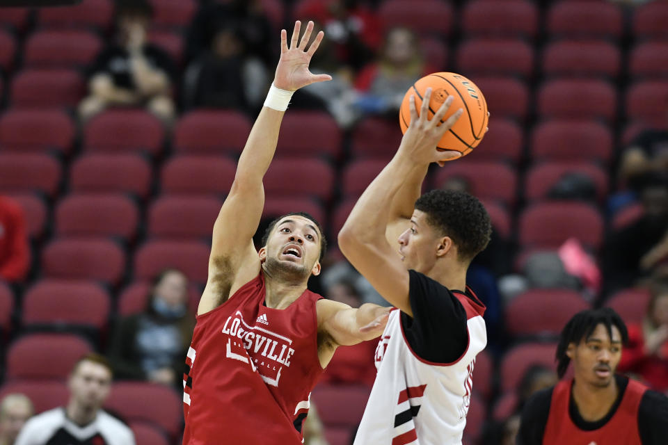 Louisville guard Mason Faulkner, left, attempts to block the pass of forward JJ Traynor during an NCAA college basketball preseason scrimmage in Louisville, Ky., Saturday, Oct. 16, 2021. (AP Photo/Timothy D. Easley)