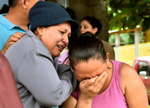 Relatives of inmates react after learning of their loved ones' fate in front of the prison in Tela, Honduras, where overnight rioting claimed at least 18 lives