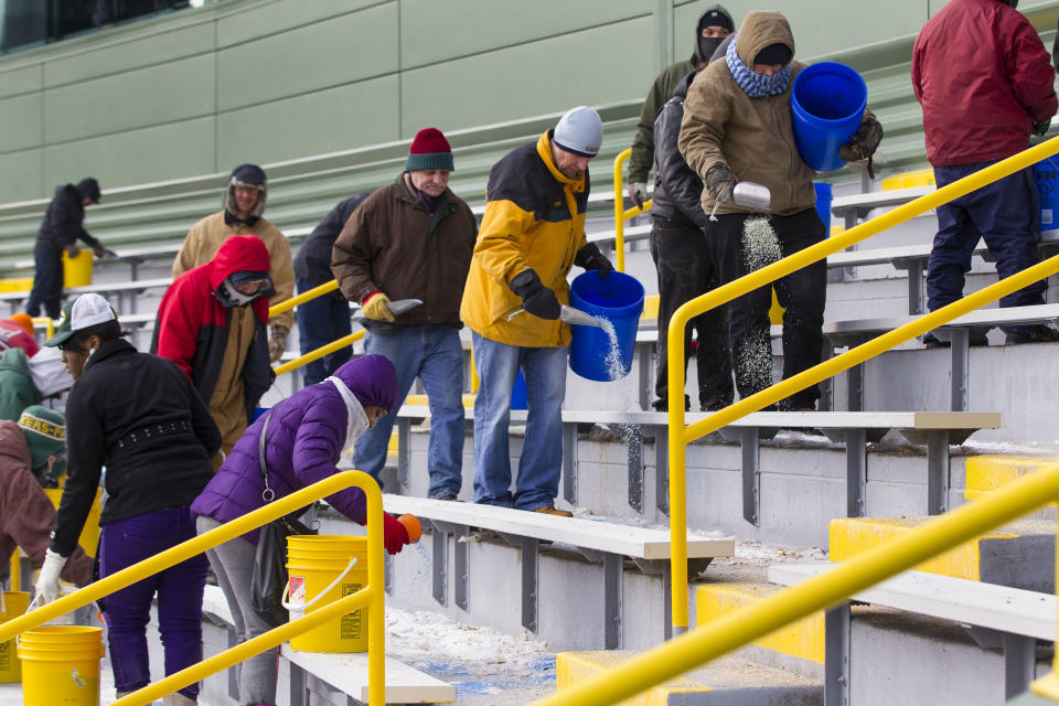 Workers clear ice and snow from the seats at Lambeau Field on Friday, Jan. 3, 2014, in Green Bay, Wis. in preparation for Sunday's NFL football wild-card playoff game between the Green Bay Packers and San Francisco 49ers. (AP Photo/Mike Roemer)