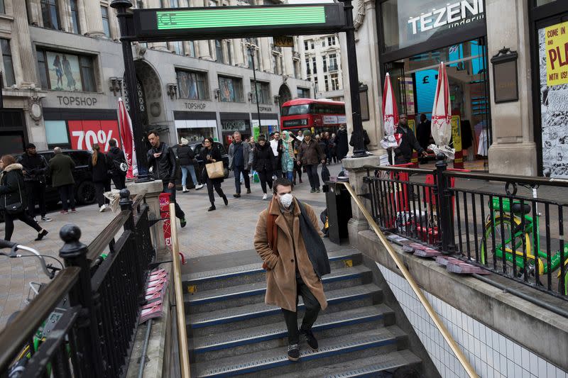 A man wears a protective mask as he walks into Oxford Circus underground station in London