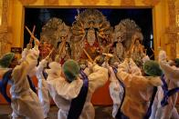 Hindu devotees perform Dandiya in front of an idol of Hindu goddess Durga in Kolkata