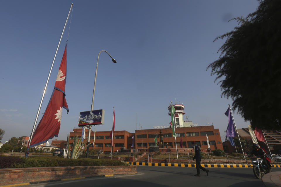 Nepal's national flag flows at half mast at Tribhuvan International Airport in Kathmandu, Nepal, Monday, Jan. 16, 2023. Nepal began a national day of mourning Monday as rescue workers resumed the search for six missing people a day after a plane to a tourist town crashed into a gorge while attempting to land at a newly opened airport, killing at least 66 of the 72 people aboard in the country's deadliest airplane accident in three decades. (AP Photo/Bikram Rai)