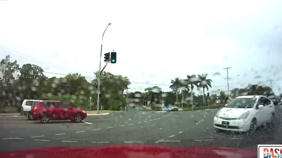 The white Prius drives straight through a red light and into oncoming traffic. Photo: Dash Cam Owners Australia