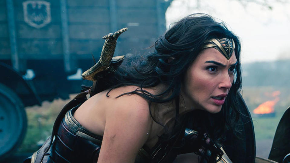 Gal Gadot as Wonder Woman crouches on a World War I battlefield.