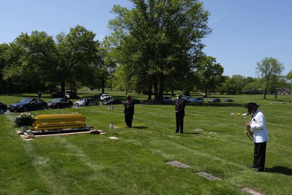 Lonnie Youngblood, right, plays saxophone while waiting for friends and family to gather for the interment of Bishop Carl Williams, Jr. in Union, N.J., Thursday, May 21, 2020. Carl Williams, Jr. was the emeritus pastor of the Institutional International Ministries, a congregation started by his father Carl Williams, Sr. The congregation and Williams Jr. are more widely known for their gospel group, the Institutional Radio Choir. Williams Jr. was a featured singer singer in, directed and managed the choir for over 30 years and took a star turn on Broadway when he was cast in the musical "The Gospel at Colonus". (AP Photo/Seth Wenig)