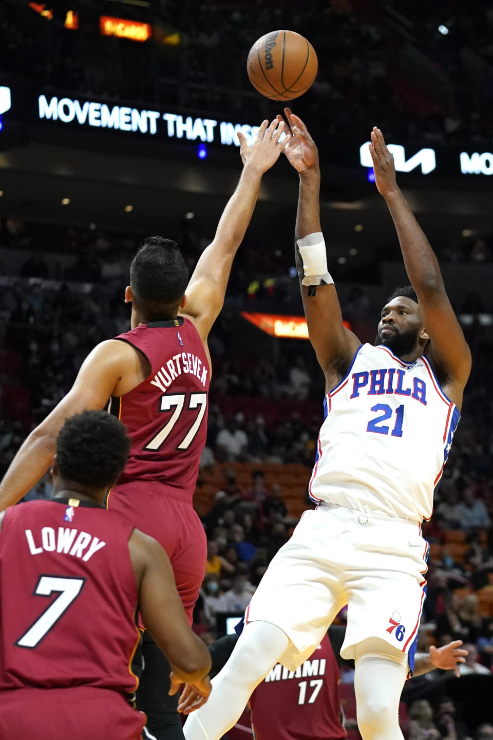 Philadelphia 76ers center Joel Embiid (21) shoots over Miami Heat center Omer Yurtseven (77) during the first half of an NBA basketball game, Saturday, Jan. 15, 2022, in Miami. (AP Photo/Lynne Sladky)