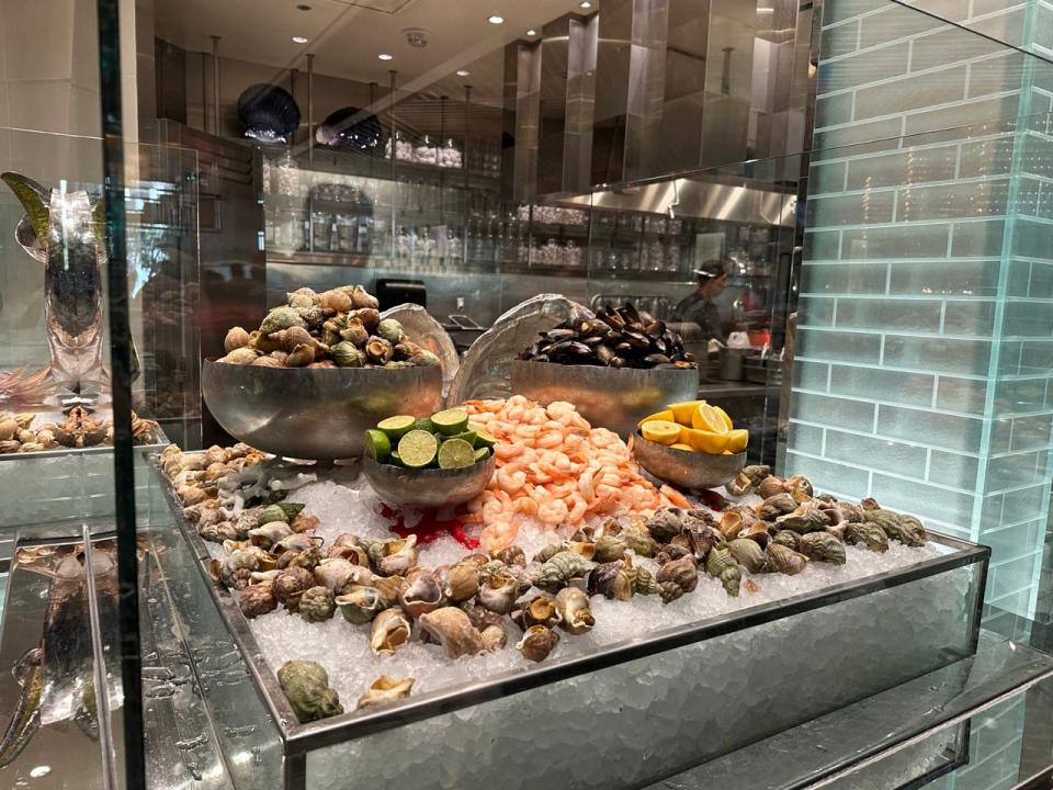 Shrimp, shells, seafood on a large ice pile in a glass display