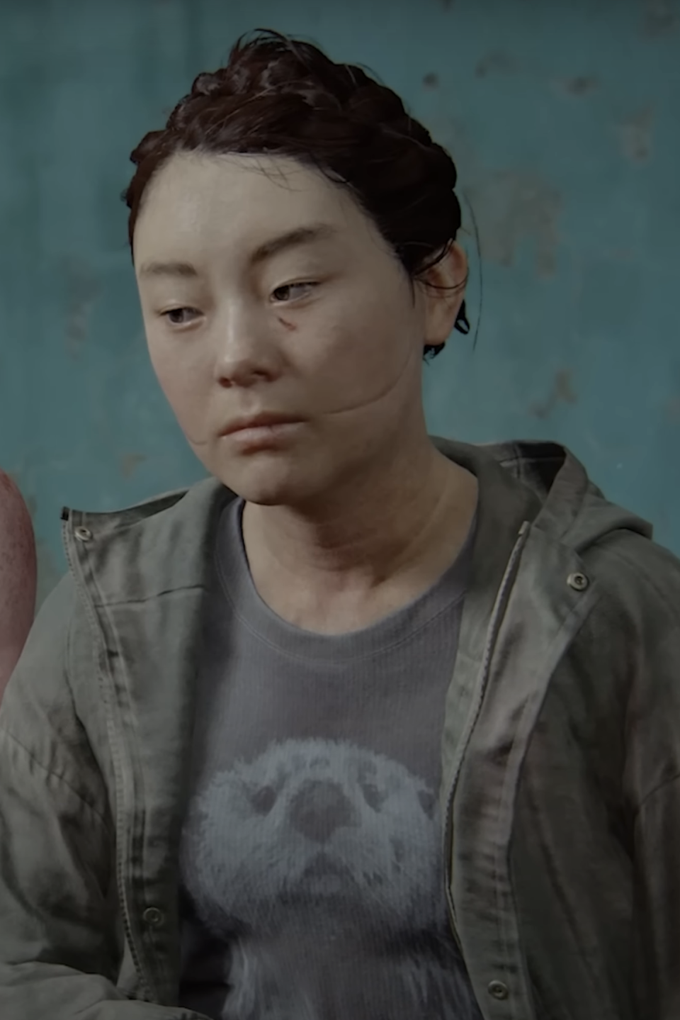 Yara in The Last of Us Part II with a concerned expression, wearing a jacket over a t-shirt with a bear graphic