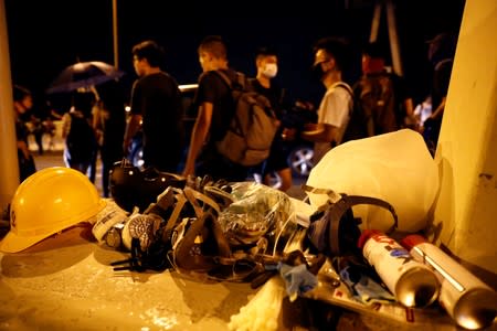 Helmets and masks are pictured as protesters walk amongst the traffic on the highway away from Hong Kong International Airport, in Hong Kong