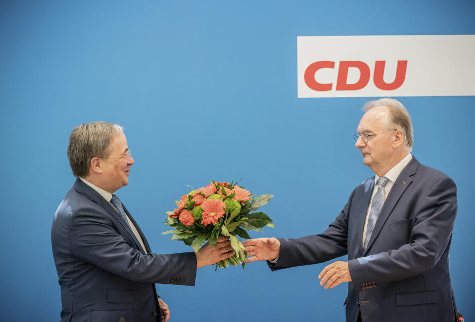 Reiner Haseloff,right, Minister President of Saxony-Anhalt, receives flowers from Armin Laschet, CDU Federal Chairman and Minister President of North Rhine-Westphalia, before the start of the CDU Federal Executive Committee meeting in Berlin, Germany, June 7,2021. The top bodies are discussing the results after the state elections in Saxony-Anhalt. (Michael Kappeler via AP, Pool)