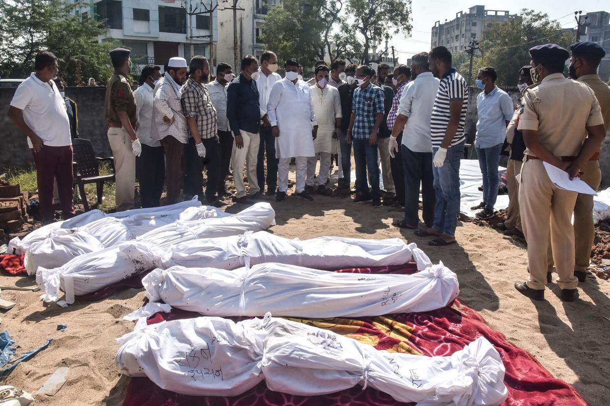 <p>Police personnel and residents gather around the bodies of victims after a truck lost control and ran over them while sleeping in Surat district.</p> (Getty images)