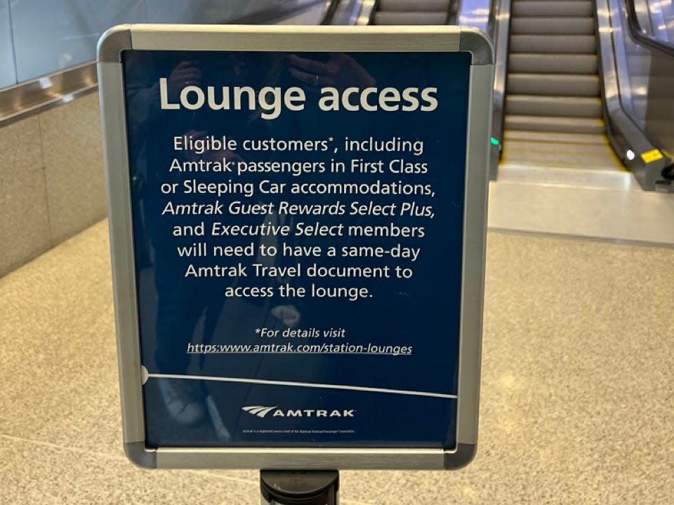Amtrak lounge access sign  in front of escalators 