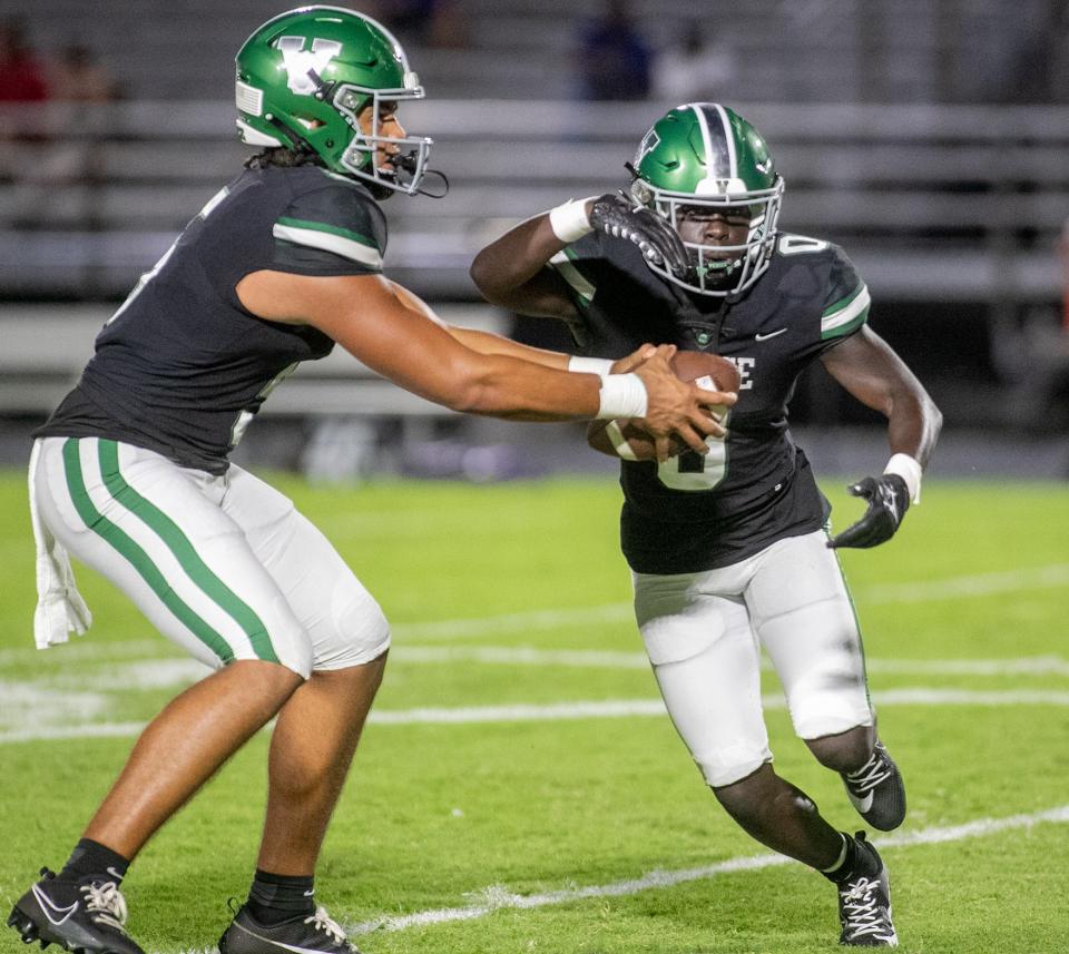 Venice quarterback Jadyn Glasser (5) feeds the ball to Alvin Johnson (0) during Friday night light action in Venice, Florida. The Venice Indians defeated the River Ridge Royal Knights 54-0. MATT HOUSTON/HERALD-TRIBUNE