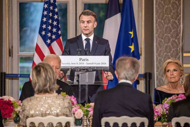 Macron habla en la cena del Palacio del Elíseo junto a Biden (Photo by Christophe PETIT TESSON / POOL / AFP)