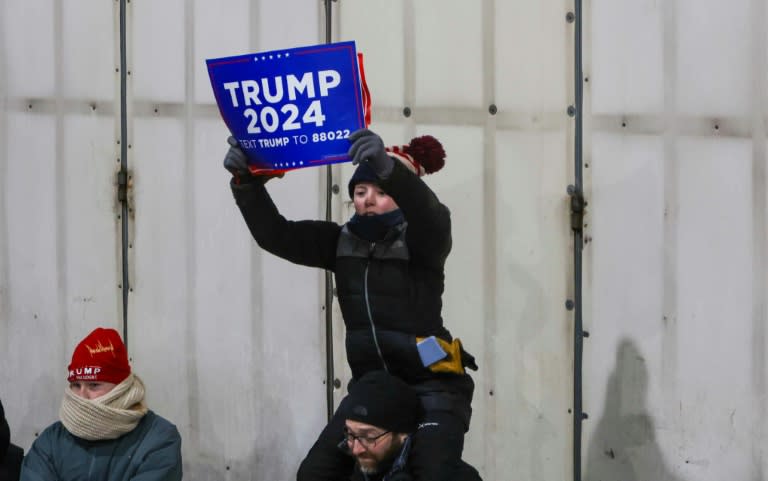 Un niño muestra un cartel en apoyo de Donald Trump antes de un acto de campaña del expresidente de EEUU y candidato republicano en Waterford Township, Michigan, el 17 de febrero de 2024 (Alex Wroblewski)