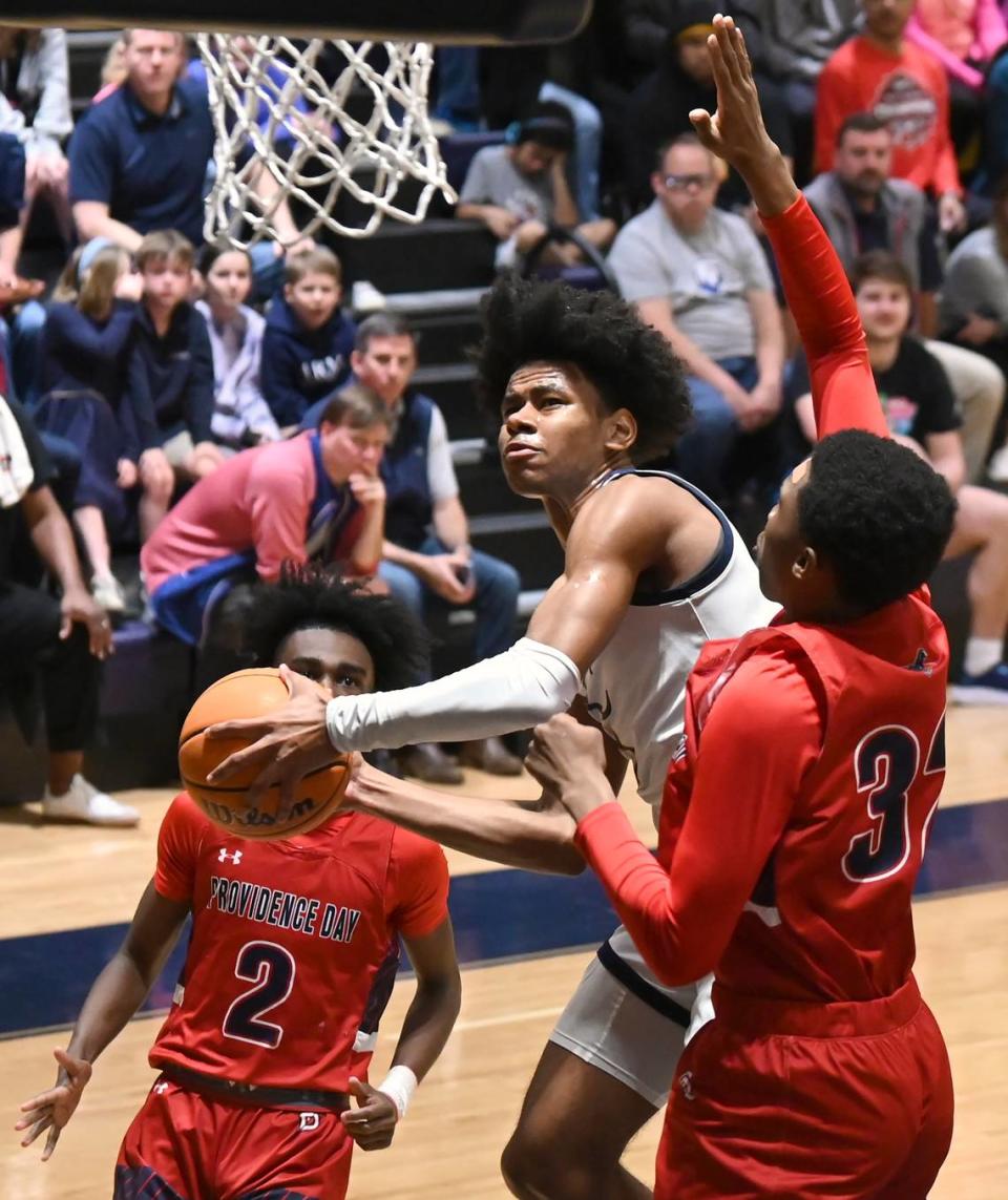 Carmel Christian’s Jaeden Mustaf, center, drives between two Providence Day defenders to the basket during first half action in the NCISAA state semifinal on Tuesday, February 21, 2023. Carmel Christian defeated Providence Day 72-55.